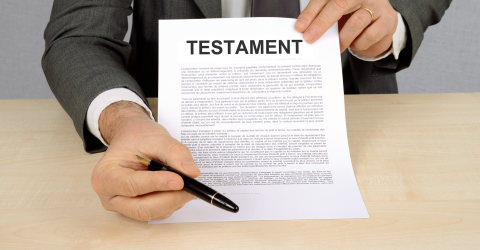 Notaris houdt een testament vast met een pen ter ondertekening
